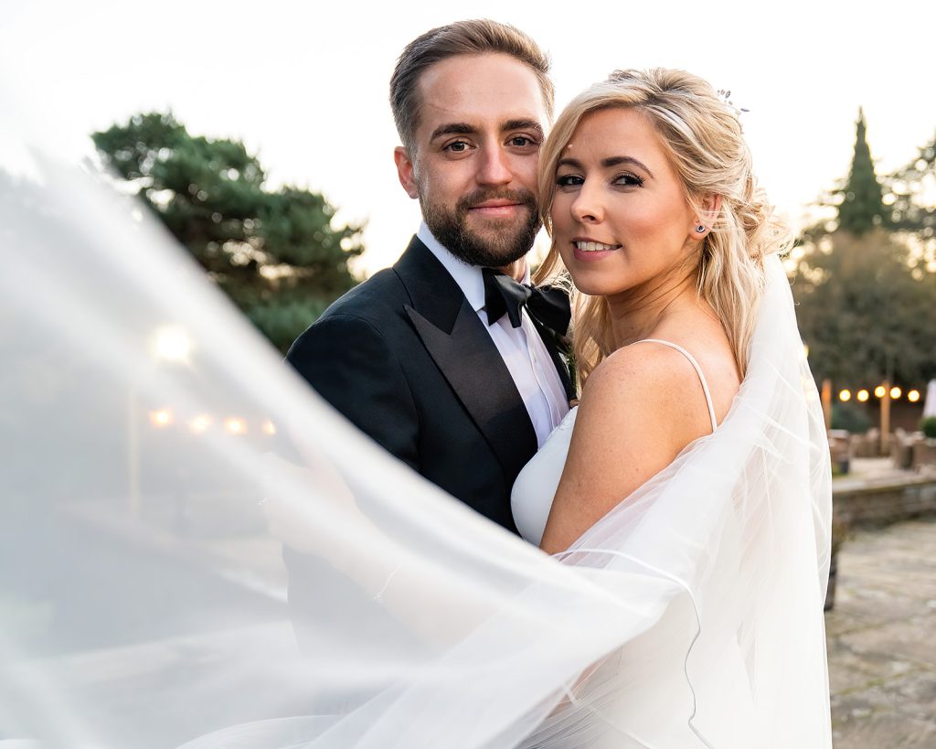 an image of a groom in blacktie and a female bride and her veil taken at Penny Hill Park Hotel & Spa in Surrey